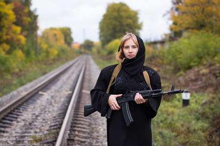 Girl with blond hair in black muslim dress with armsの写真素材