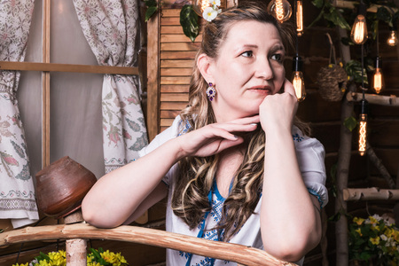 Ugly woman in traditional dress posing in a rustic interior