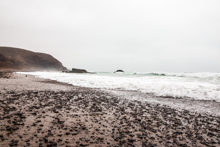 Coast, wave, beach and a large rock with archの写真素材