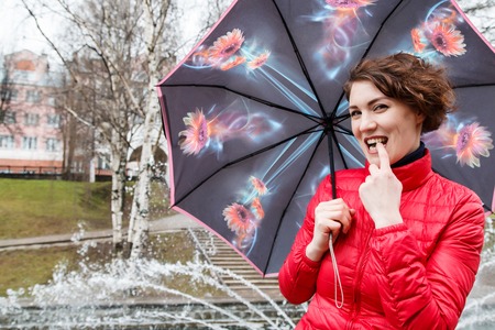 Girl with umbrella outdoor in a raining dayの写真素材