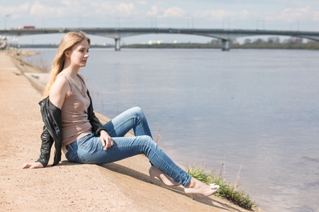Girl with blond hair on the promenade near riverの写真素材