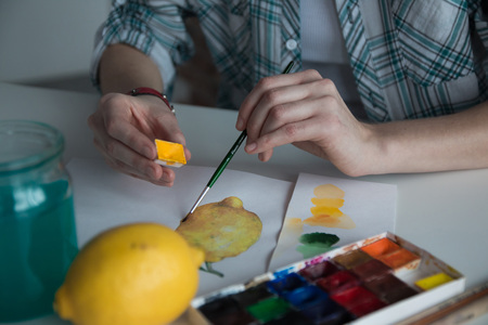 Female artist's hand on the table and the pictureの写真素材