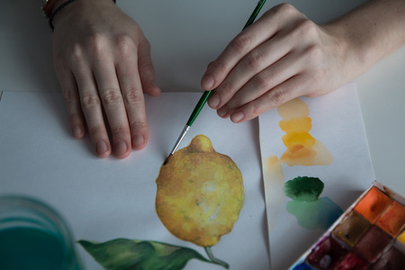 Female artist's hand on the table and the pictureの写真素材
