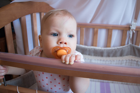 Small child in a baby cot in the room