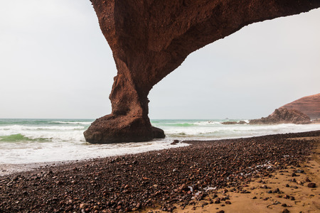 Coast, wave, beach and a large rock with archの写真素材
