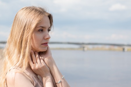 Girl with blond hair on the promenade near riverの写真素材