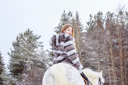 Nice girl and white horse outdoor in a winter dayの写真素材