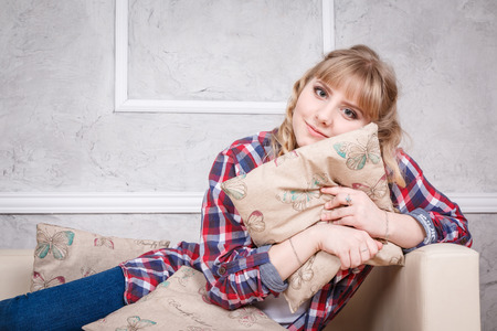 Nice blond girl on the sofa in the bright roomの写真素材