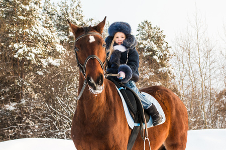 Small girl and horse in a winter dayの写真素材