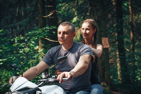 The motorcyclist and the girl on the roadの写真素材