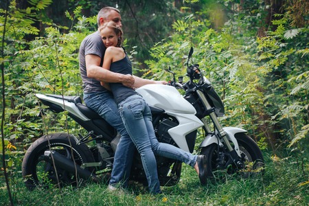 The motorcyclist and the girl in the forestの写真素材