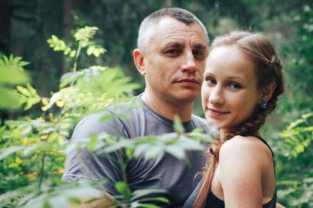 Adult man and a young girl in the forestの写真素材