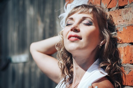 Portrait of blonde girl near brick wallの写真素材