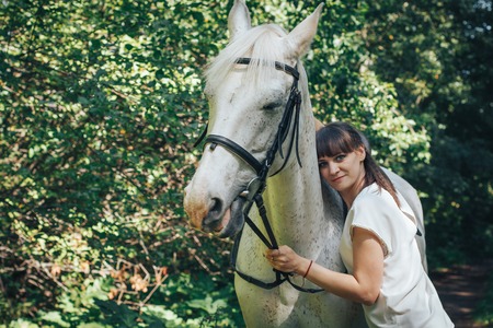 Girl and horse in the woods in a summer dayの写真素材