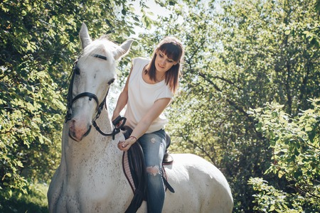 Girl and horse in the woods in a summer dayの写真素材