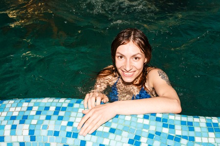 Wet girl in the swimming-pool in the eveningの写真素材