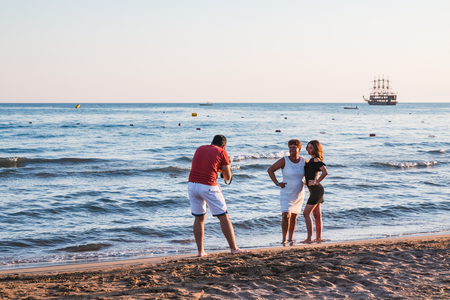 Side, Turkey - June 24, 2107: Photographer takes picture of model on the beach in the evening in Side city in Turkeyのeditorial素材