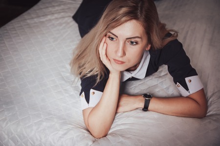 Nice blond girl on the bed indoorsの写真素材
