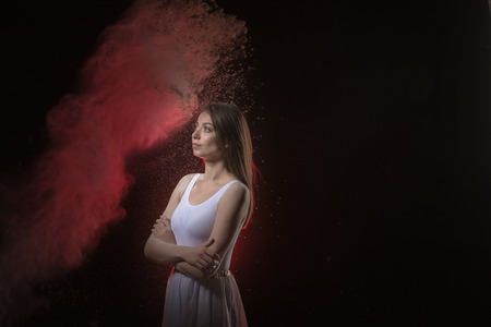 Beautiful slim female dancer in white dress in studio during Powder Photo Shoot with colored lightの写真素材