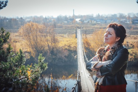 Woman on the suspension bridge in autumn dayの写真素材