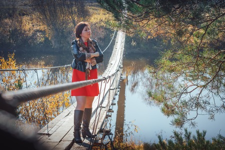 Woman on the suspension bridge in autumn dayの写真素材