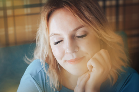 Blond woman in blue dress have rest in cafe