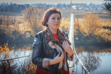 Woman on the suspension bridge in autumn dayの写真素材