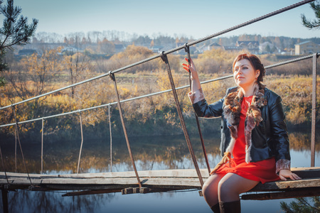Woman on the suspension bridge in autumn dayの写真素材