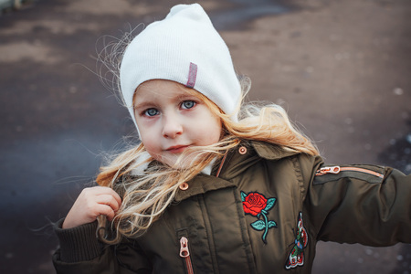 Portrait of small blonde girl in white hat outdoorsの写真素材