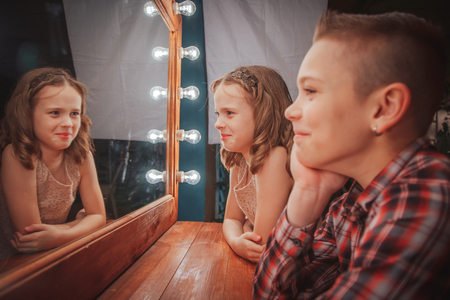 Nice children boy and girl have fun near mirrorの写真素材