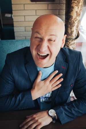 Funny russian businessman sitting in a restaurantの写真素材