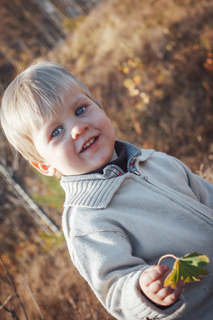 Happy baby boy outdoors with white hair in an autumn dayの写真素材