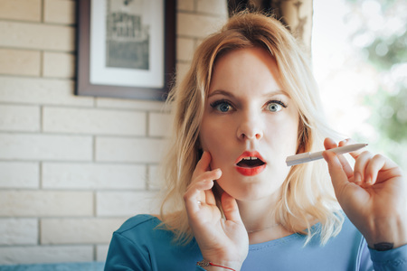 Blond woman in blue dress have rest in cafeの写真素材