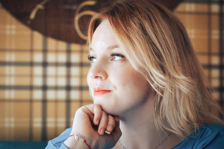 Blond woman in blue dress have rest in cafeの写真素材