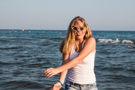 Blond teenager girl on the beach near sea or oceanの写真素材