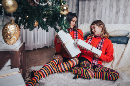 Two girls sisters have relax and fun in a nice room decorated for Christmas and the New yearの写真素材