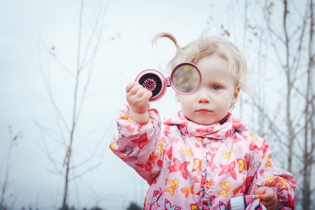 Portrait of a child of a little girl in a warm hat and warm clothes in an autumn dayの写真素材