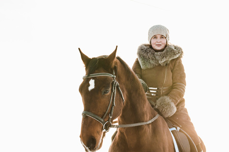 Woman in brown dress and brown horse in a winter dayの写真素材