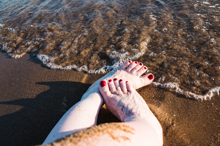Female feet and sea wave on a summer dayの写真素材