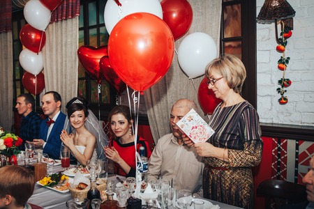 Kirov, Russia - November, 24, 2017: Bride and groom behind the decorated table at the wedding banquet and the guests sit nearestのeditorial素材
