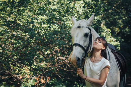Girl and horse in the woods in a summer dayの写真素材