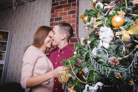 Young couple celebrating Christmas in the room decorated for Mary Christmas and New yearの写真素材