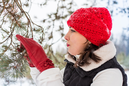 Portrait of girl in a red cap and warm jacket in the forest in a winterの写真素材
