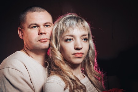 Man and woman in a white dresses lighted colored light in studio and black background