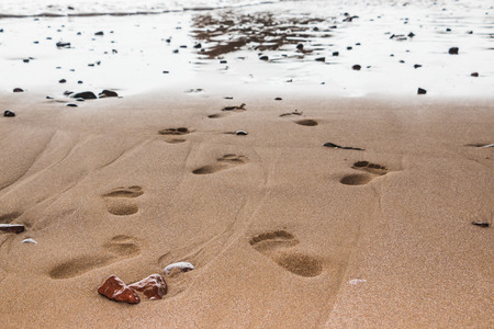 Coast, waves and beach with yellow sand and small pebbles