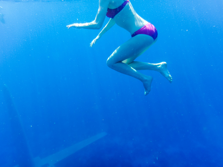 Swimmer under clear blue water while snorkeling