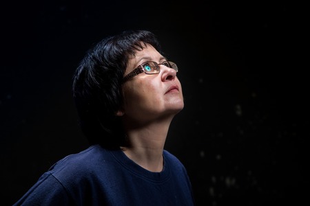 Portrait of brunette adult woman with black background