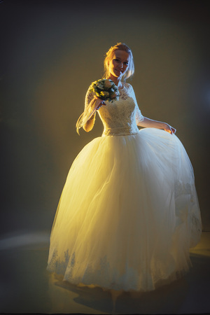 Beautiful bride in a white dress in the Studio during a photoshoot with nice lightの写真素材
