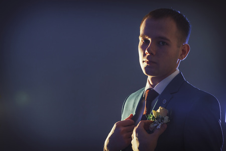 Portrait handsome groom in a blue suit in the Studio during a photoshoot with nice lightの写真素材