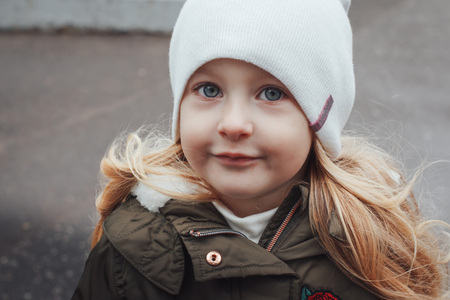 Portrait of small blonde girl in white hat outdoorsの写真素材